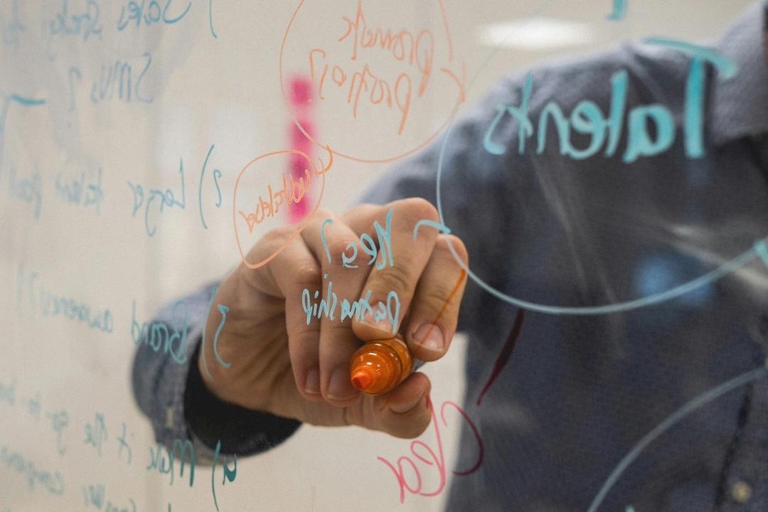 Software developer using a marker on a glass board to plan property-based testing in Python with Hypothesis, visualizing code strategies and test cases.