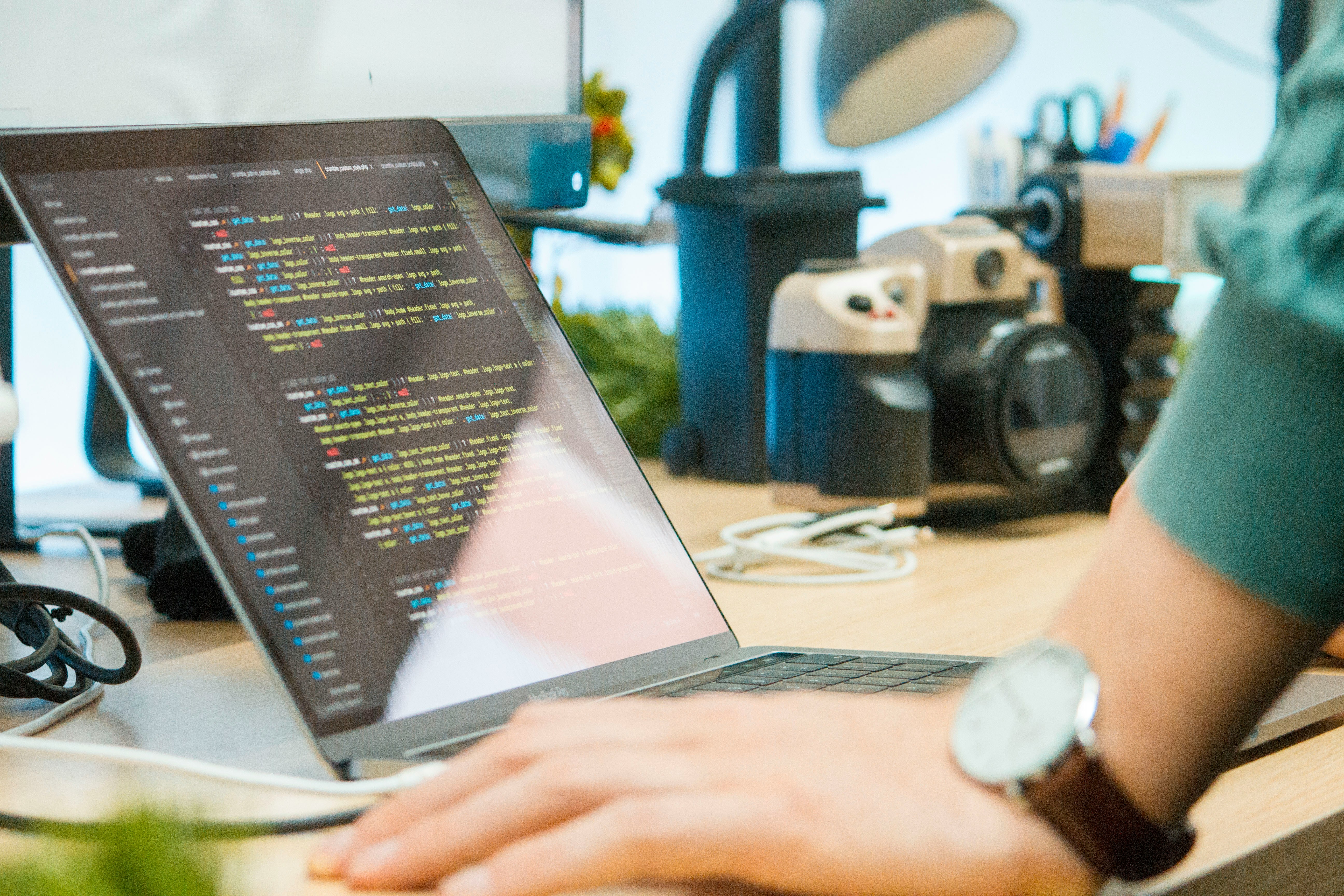 Person coding on a laptop with colorful code editor display in a modern workspace, emphasizing a Python Generics Tutorial and showcasing practical programming tools.